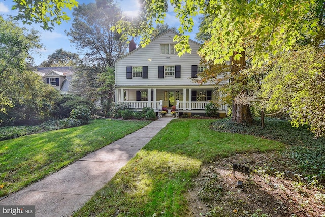 view of front of house with a front yard and a porch