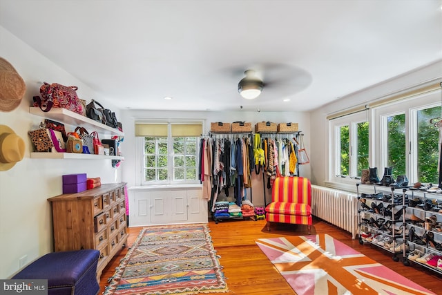 bedroom with hardwood / wood-style flooring, radiator, and ceiling fan