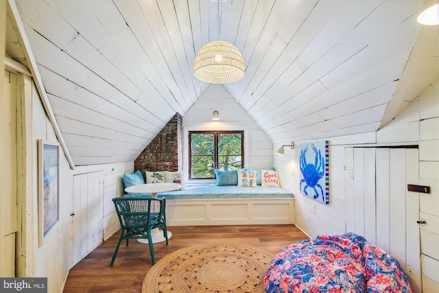 bedroom with lofted ceiling, wood ceiling, wooden walls, and light hardwood / wood-style floors