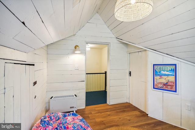 bonus room featuring vaulted ceiling, wood ceiling, wood walls, and wood-type flooring