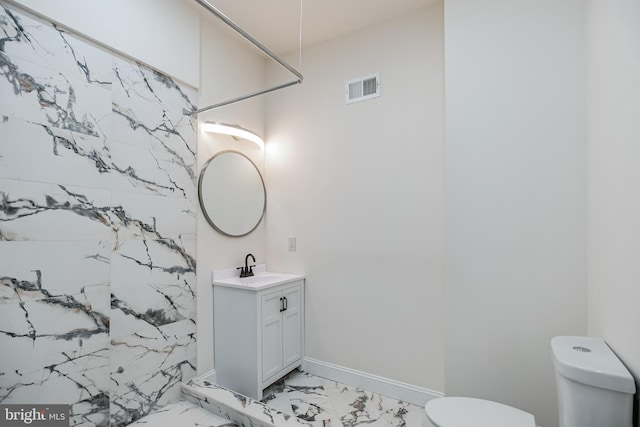 bathroom with a shower, vanity, and toilet