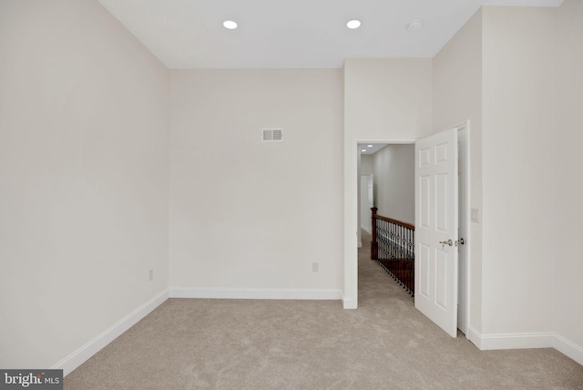 unfurnished room featuring light carpet