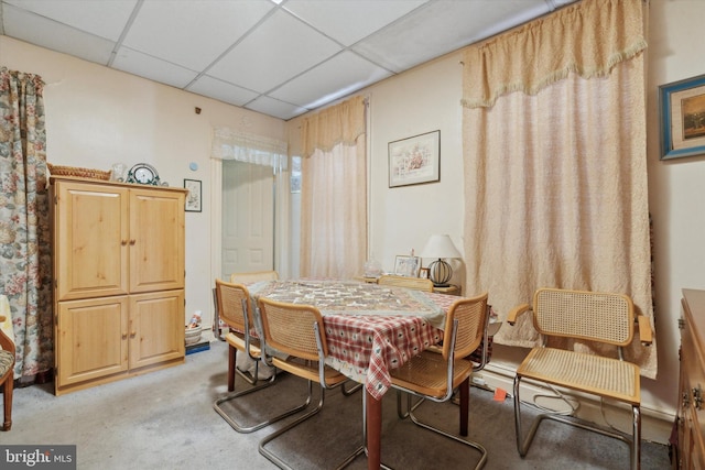 carpeted dining room with a drop ceiling