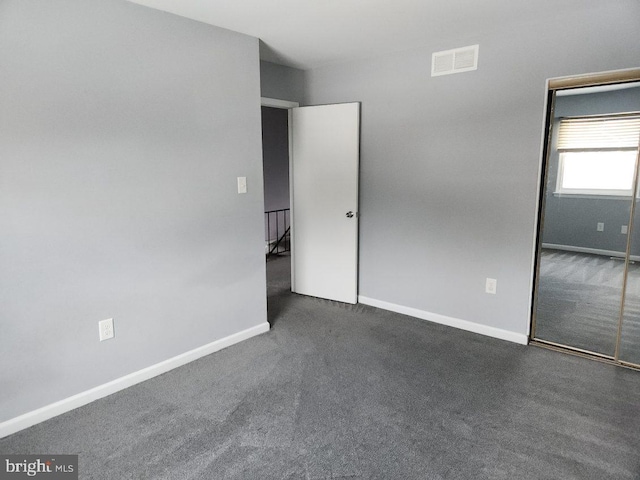 unfurnished bedroom with dark carpet