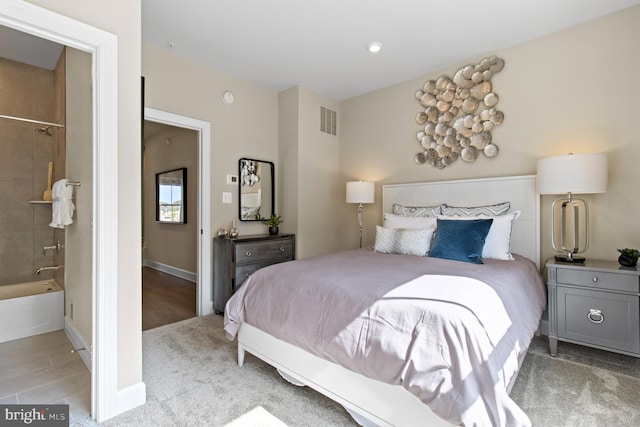 carpeted bedroom featuring ensuite bath