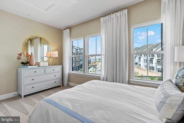 bedroom with light colored carpet and multiple windows