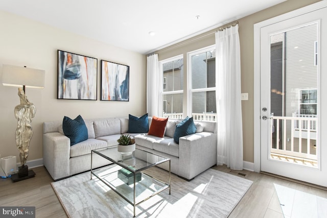 living room featuring light wood-type flooring and a wealth of natural light