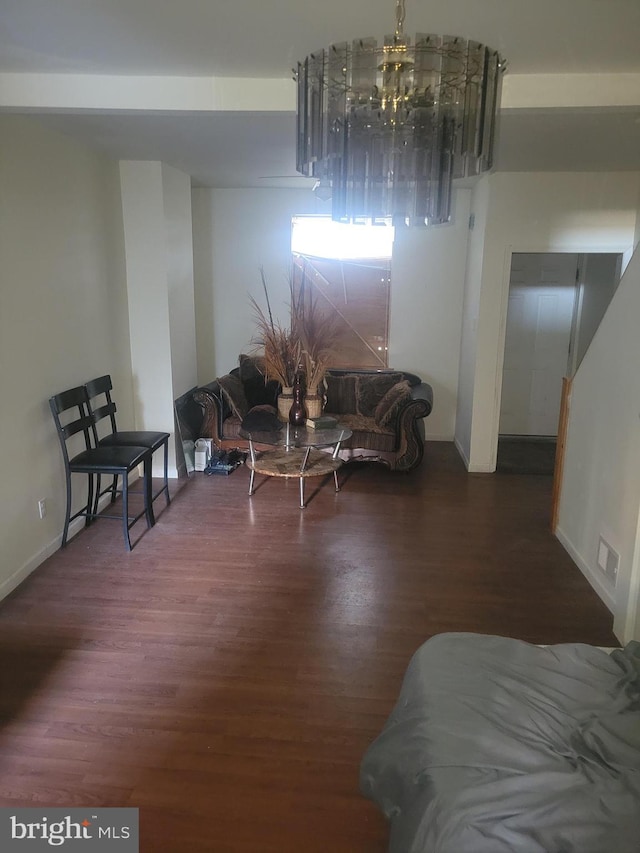 living room with dark wood-type flooring and a notable chandelier