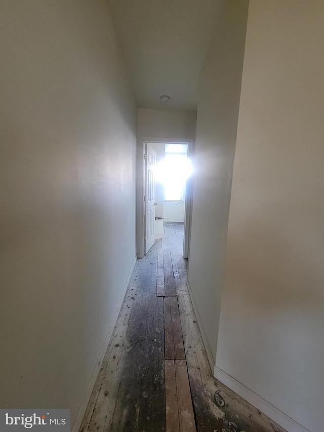 corridor with hardwood / wood-style flooring