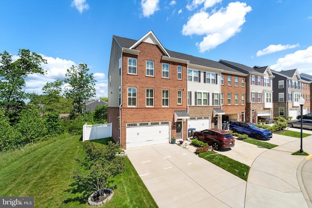 view of property featuring a garage and a front lawn