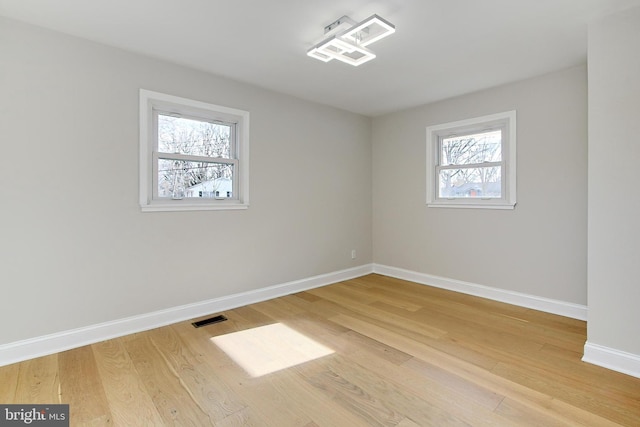 spare room featuring hardwood / wood-style floors and a healthy amount of sunlight