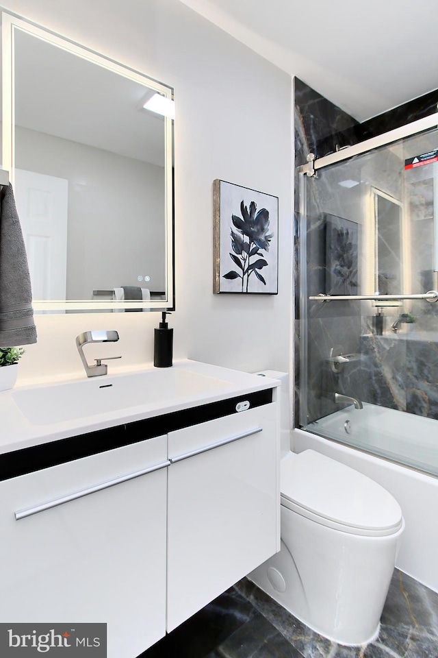 full bathroom with combined bath / shower with glass door, vanity, and toilet