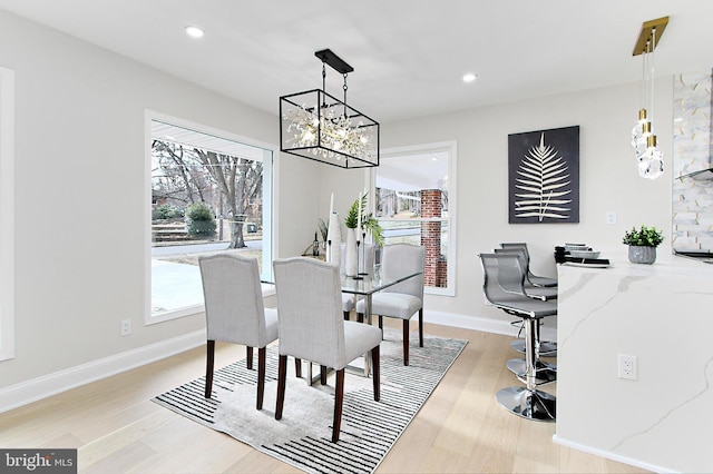 dining space with light hardwood / wood-style flooring and a chandelier