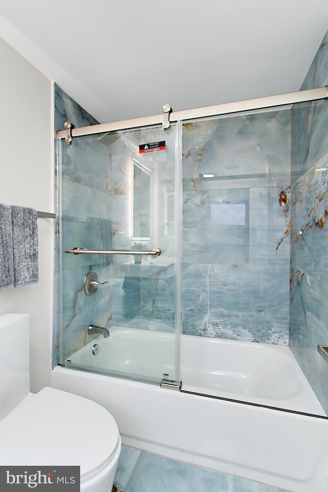 bathroom featuring toilet and combined bath / shower with glass door