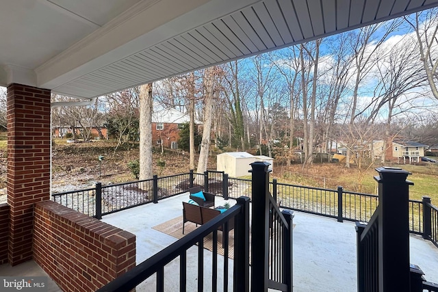 wooden deck with a storage unit and an outdoor hangout area