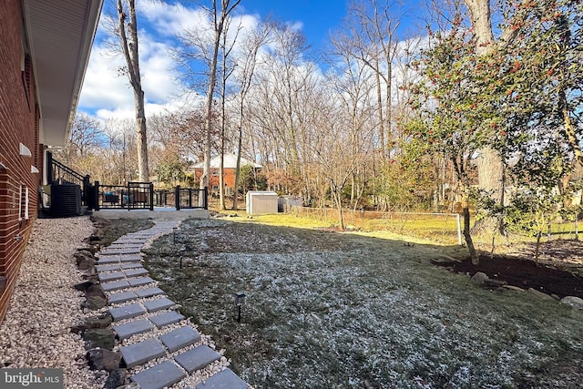 view of yard featuring cooling unit and a shed