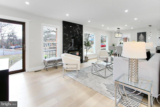 living room with light wood-type flooring and a premium fireplace