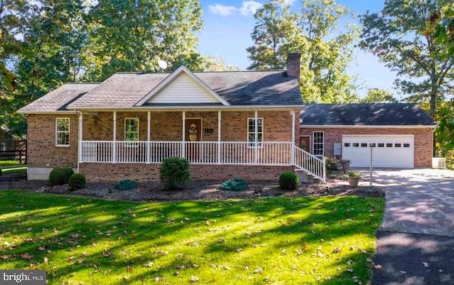 view of front of house featuring a garage, covered porch, and a front yard