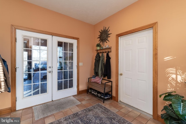 entryway featuring light tile patterned floors, french doors, and a textured ceiling