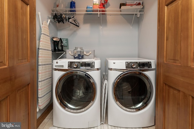 washroom with light tile patterned flooring and washer and dryer