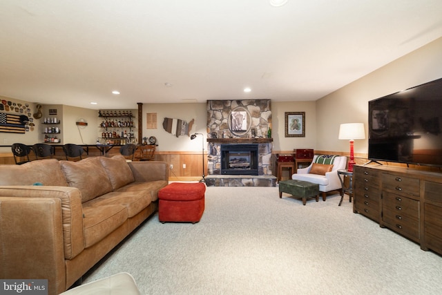 carpeted living room featuring a fireplace and wood walls