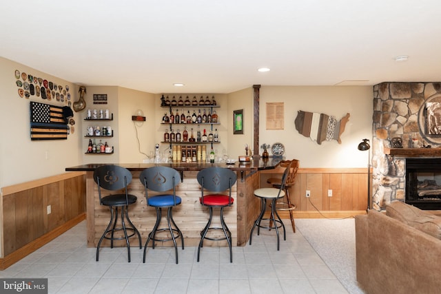 bar featuring a fireplace and wooden walls