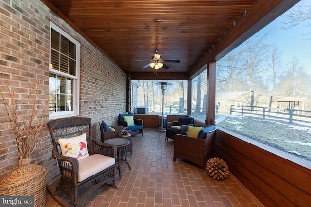 sunroom featuring ceiling fan and wooden ceiling