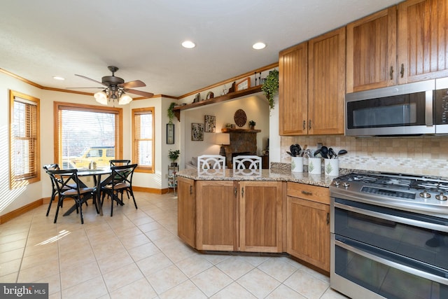 kitchen featuring tasteful backsplash, crown molding, light stone counters, light tile patterned floors, and stainless steel appliances