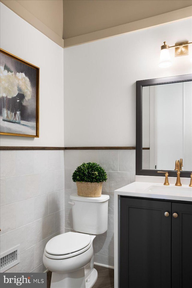 bathroom featuring tile walls, vanity, and toilet