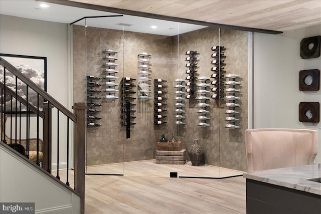 wine room with light hardwood / wood-style floors and wood ceiling