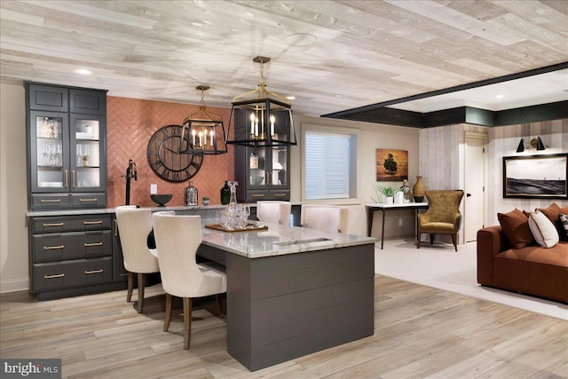 dining area featuring an inviting chandelier, wooden walls, light hardwood / wood-style floors, and wood ceiling