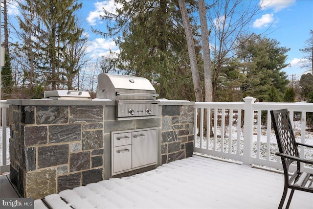 snow covered patio featuring a deck and area for grilling