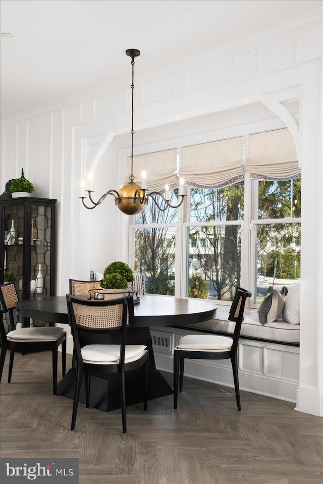 dining room featuring dark parquet flooring and crown molding