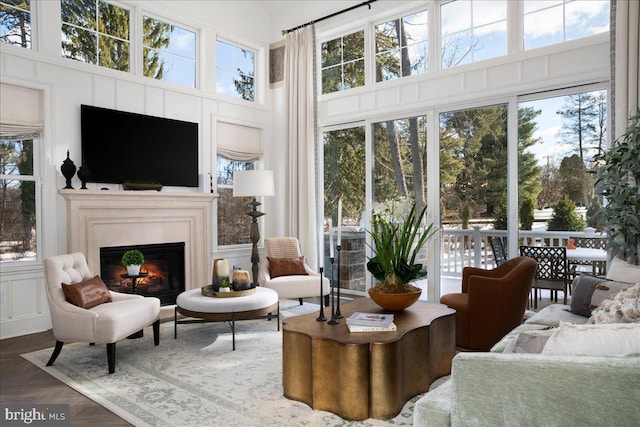 living room featuring a healthy amount of sunlight, a towering ceiling, and dark parquet floors