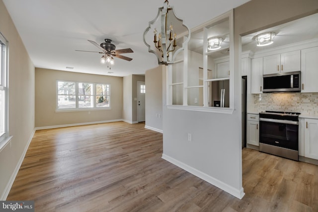 kitchen with decorative backsplash, light wood-type flooring, stainless steel appliances, and white cabinetry