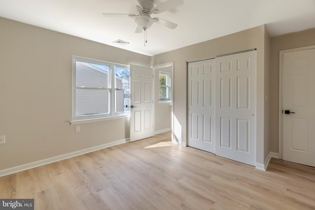 unfurnished bedroom featuring ceiling fan, a closet, and light wood-type flooring