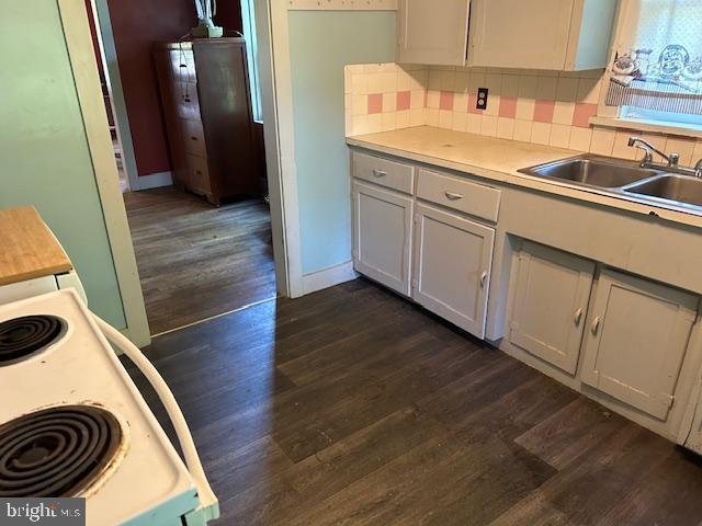 kitchen with white cabinetry, sink, dark wood-type flooring, and white range