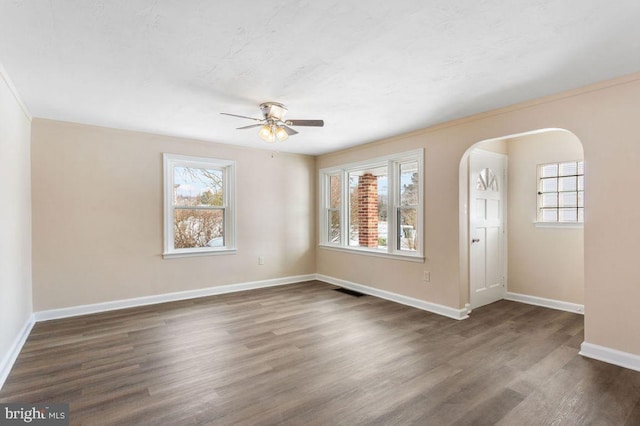 unfurnished room featuring ceiling fan, dark hardwood / wood-style floors, and plenty of natural light