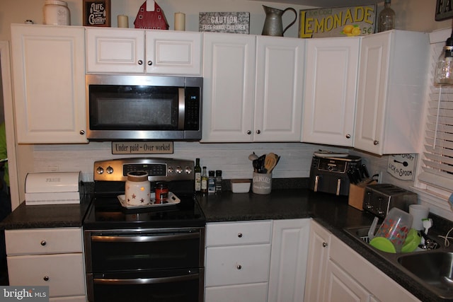 kitchen with white cabinetry, sink, backsplash, and range with two ovens