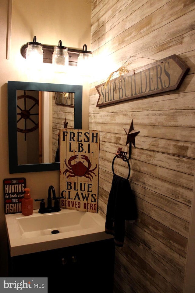 bathroom with vanity and wood walls