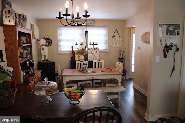 dining space featuring dark wood-type flooring and a notable chandelier