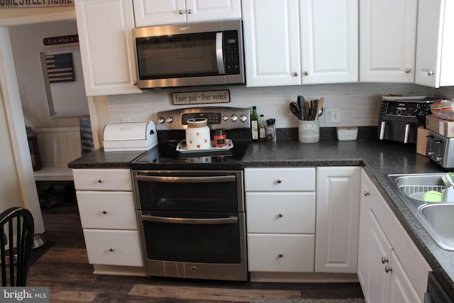 kitchen featuring white cabinetry, appliances with stainless steel finishes, and dark hardwood / wood-style floors