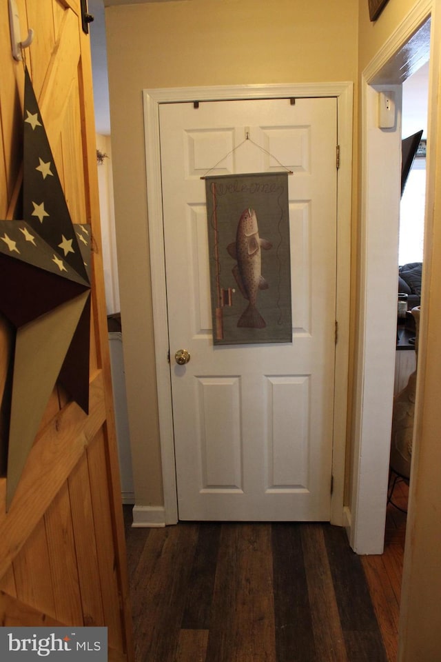 entryway featuring a barn door and dark wood-type flooring