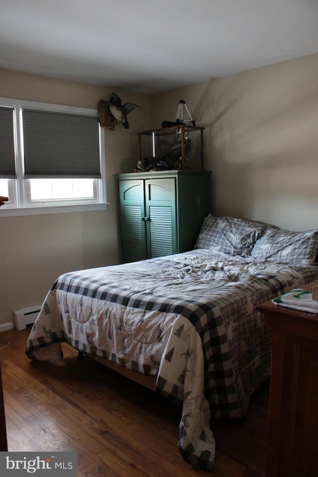 bedroom featuring hardwood / wood-style floors and a baseboard radiator