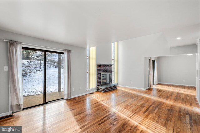 unfurnished living room with a fireplace and light hardwood / wood-style floors