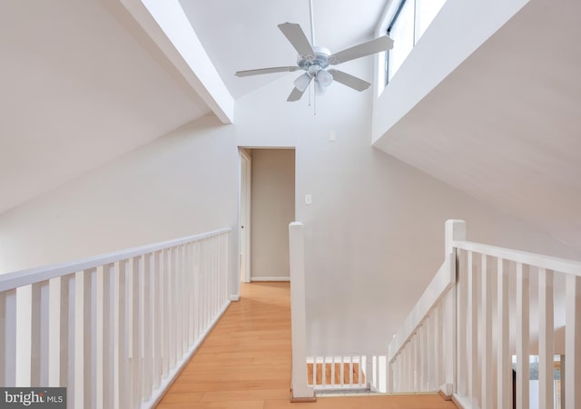 hall featuring light wood-type flooring and vaulted ceiling