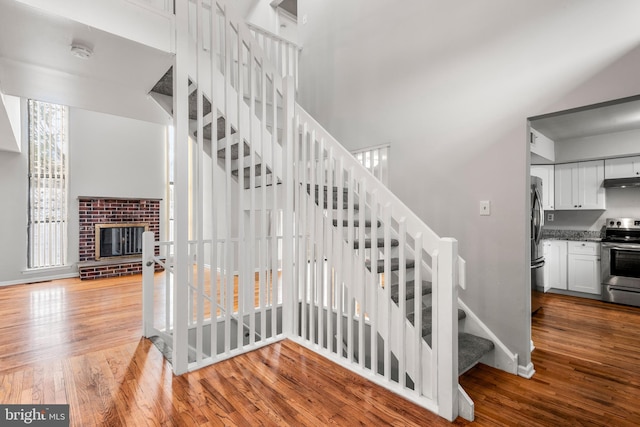 stairs featuring hardwood / wood-style flooring and a fireplace