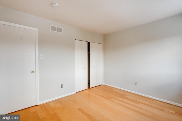 unfurnished bedroom with hardwood / wood-style flooring and a closet