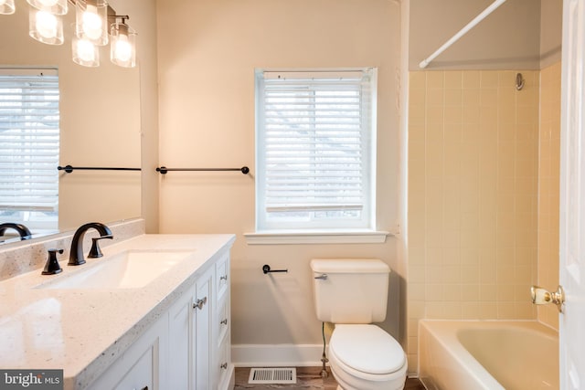 full bathroom with vanity, toilet, and tiled shower / bath combo