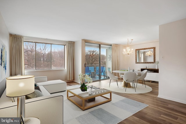 living room featuring wood-type flooring and an inviting chandelier